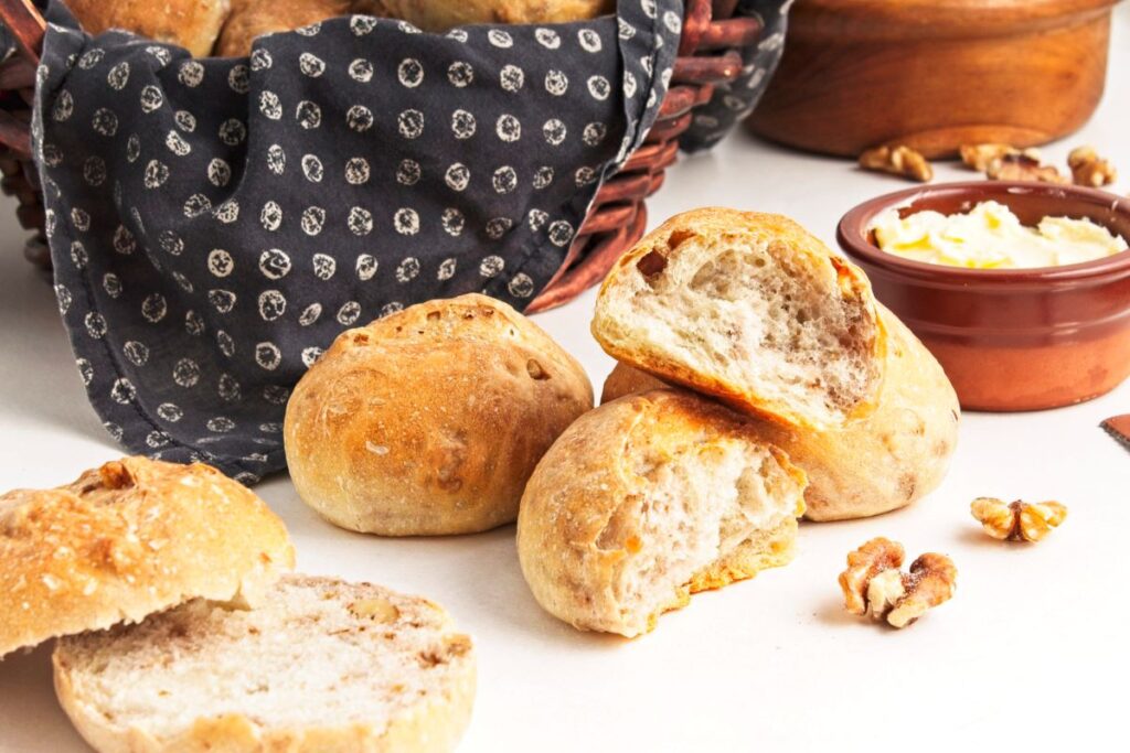 Crusty walnut loaves next to a basket.