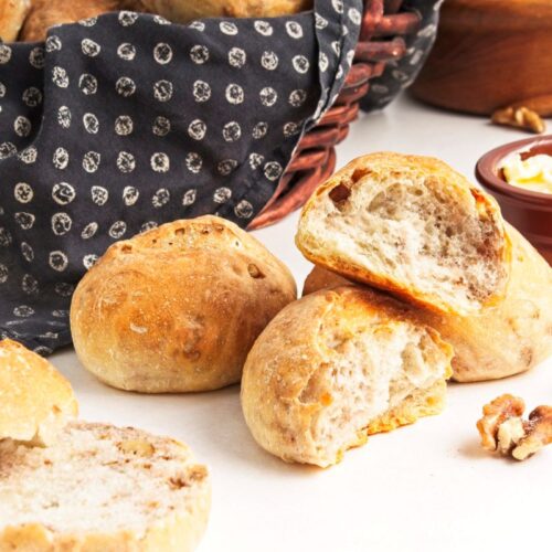 Crusty walnut loaves next to a basket.