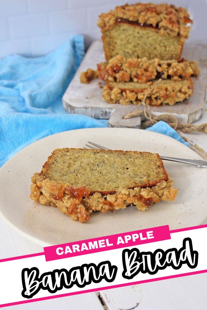 A slice of caramel apple banana bread sits on a plate with a fork, while the loaf with a crumbly caramel apple topping is on a wooden board in the background. A blue cloth is nearby. Text reads "Caramel Apple Banana Bread.
