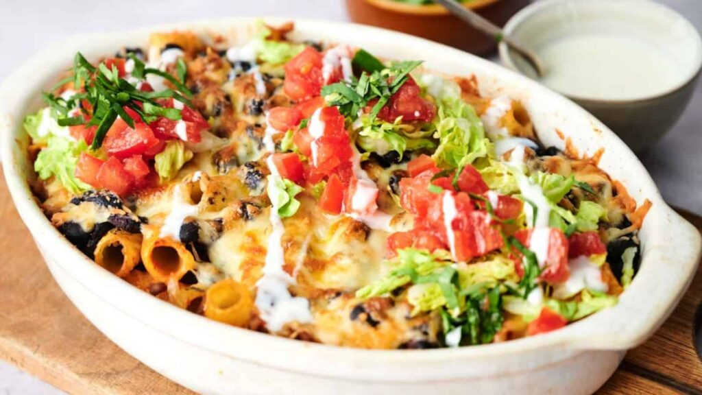 Baked pasta with melted cheese, fresh tomatoes, lettuce, and a creamy dressing.