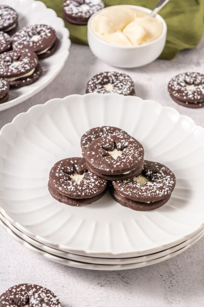 Stacked chocolate linzer cookies with cream cheese filling
