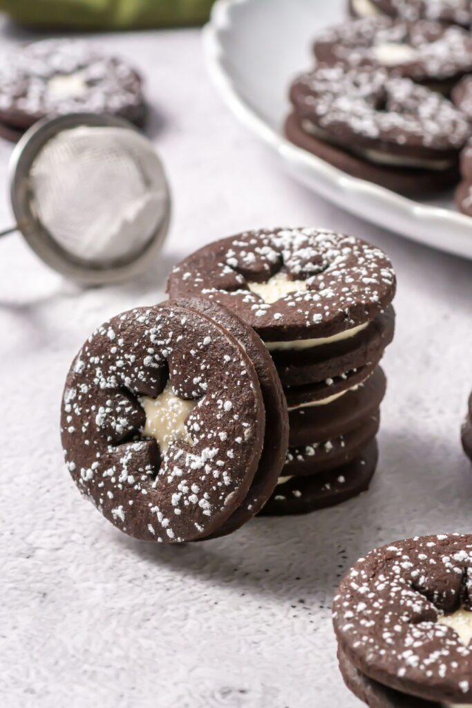 Chocolate linzer cookies filled with cream cheese frosting close-up