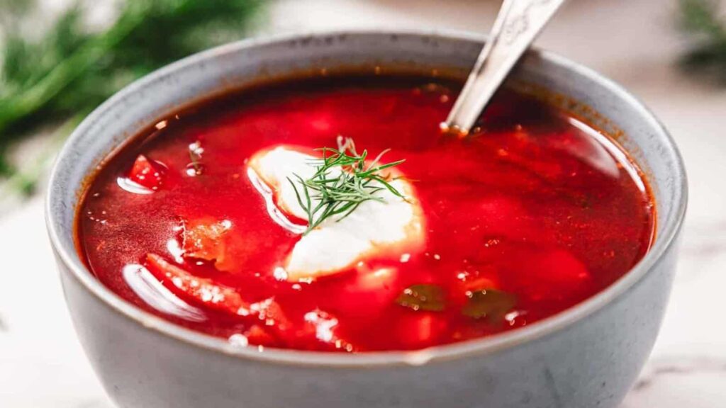 blue bowl with red chicken borscht soup