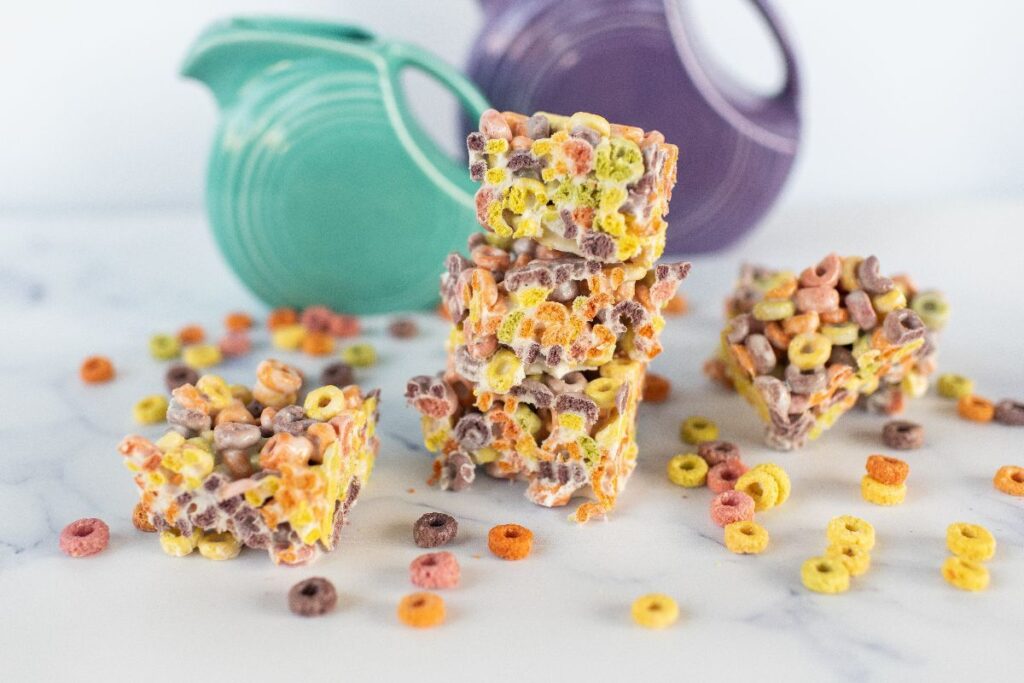 Colorful Fruit Loops squares with scattered cereal create a playful treat.