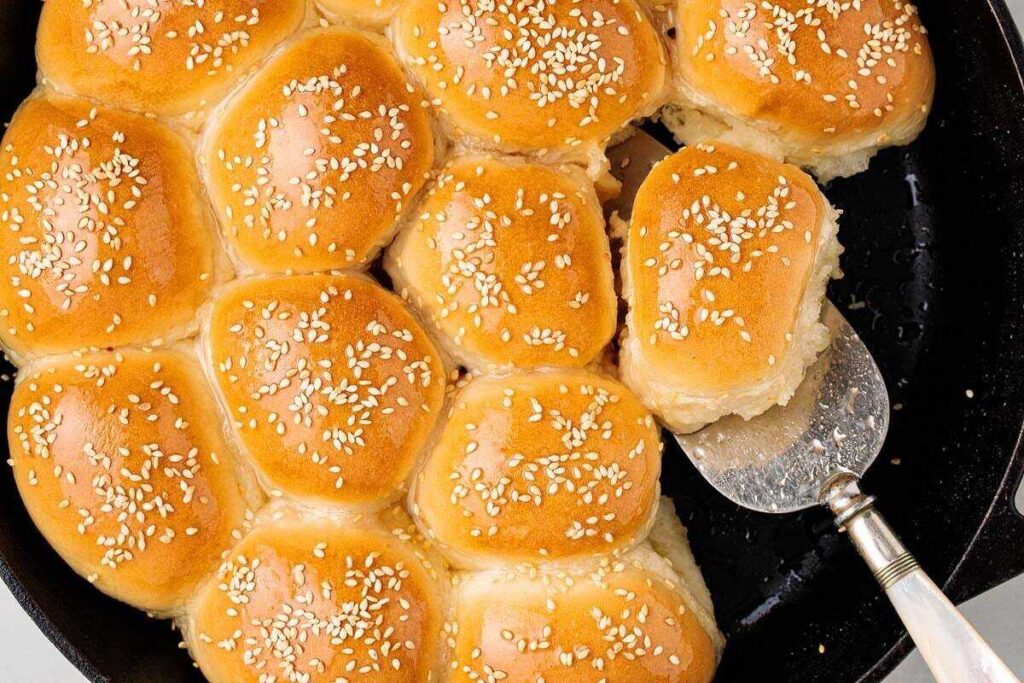 Golden honeycomb bread rolls with sesame seeds, served fresh from the skillet.