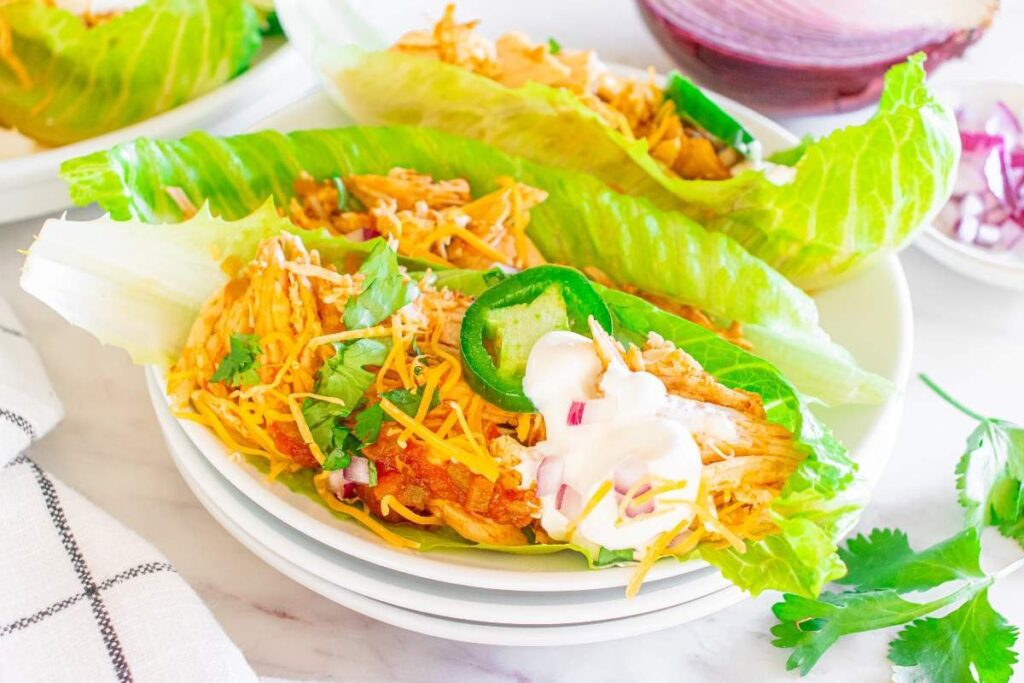 Easy Instant Pot chicken taco lettuce wraps with cheese, jalapeños, sour cream, and cilantro.