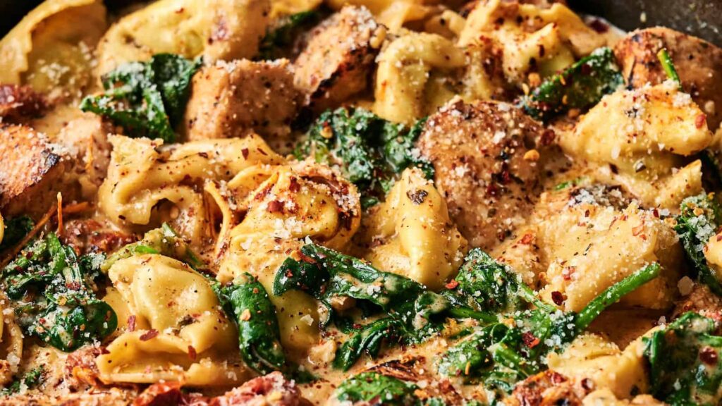 Cheese tortellini in a creamy sauce with spinach, grilled chicken, and sprinkled parmesan cheese.