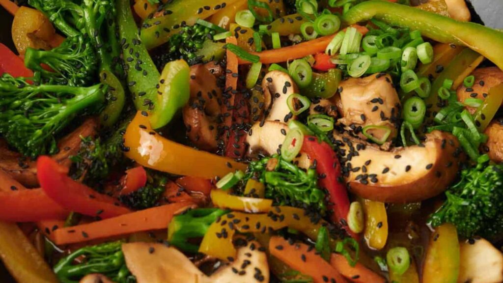 Stir fried vegetables in a pan with sesame seeds.