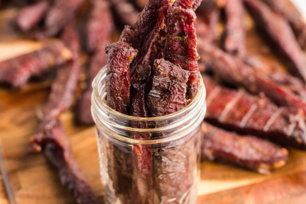 Healthy homemade beef jerky ready in a smoker like a Traeger. 