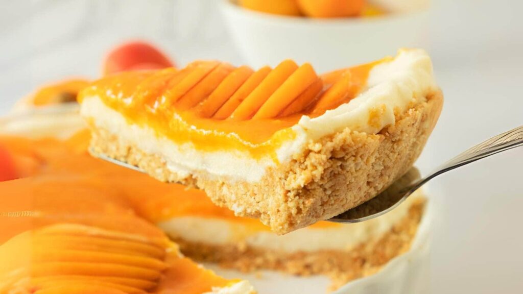 A spatula lifting up a piece of apricot tart.