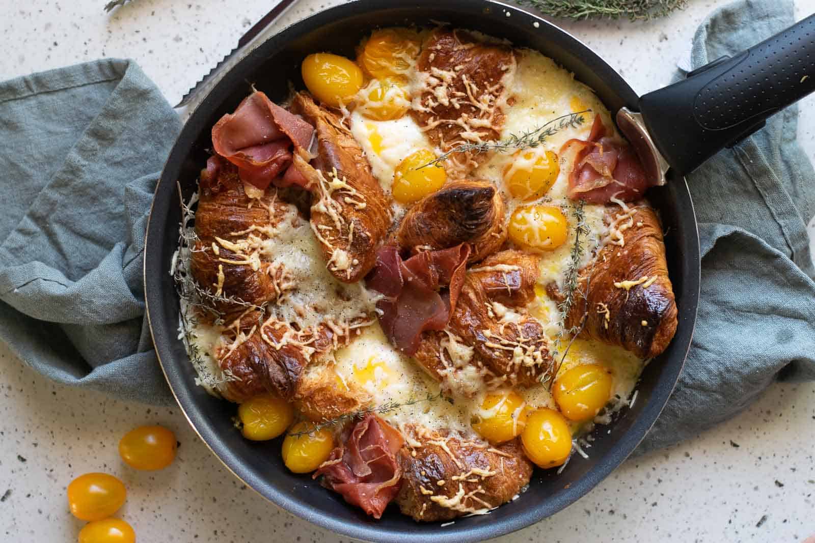 Overhead view of a croissant breakfast casserole in a skillet ready to be baked.