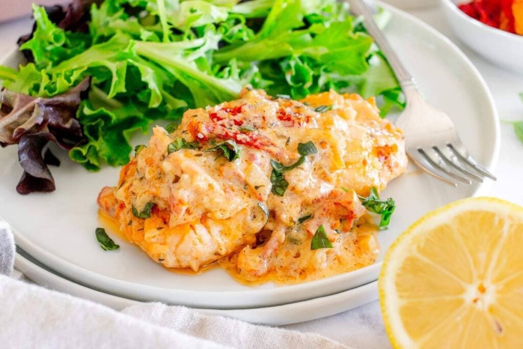 Creamy salmon served with fresh greens and a lemon half.