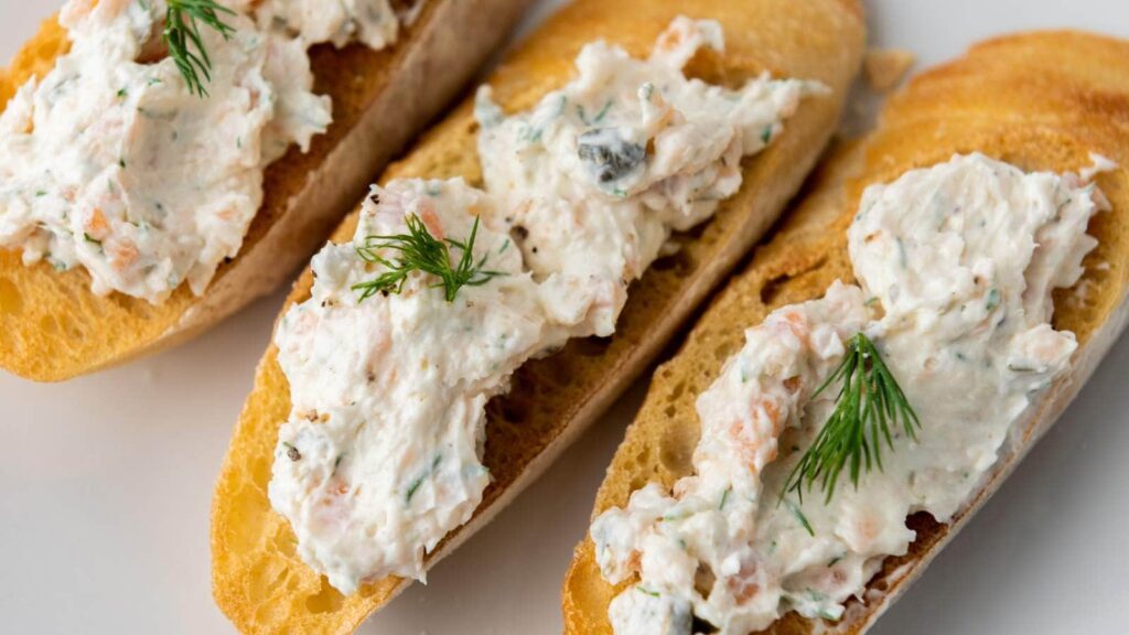 Three pieces of bread topped with smoked salmon dip.