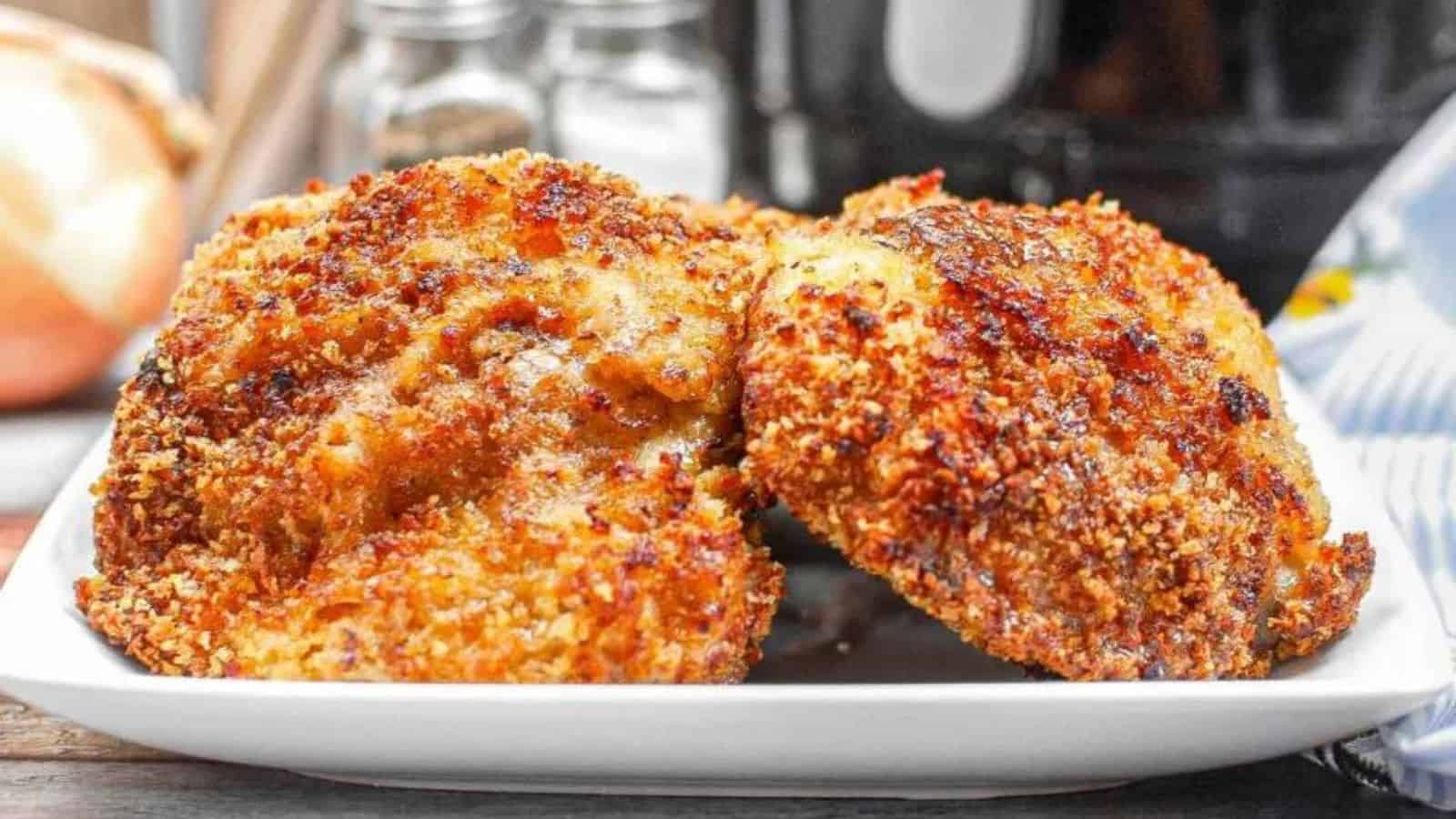 Crispy panko-coated chicken thighs served on a white plate with a side garnish.