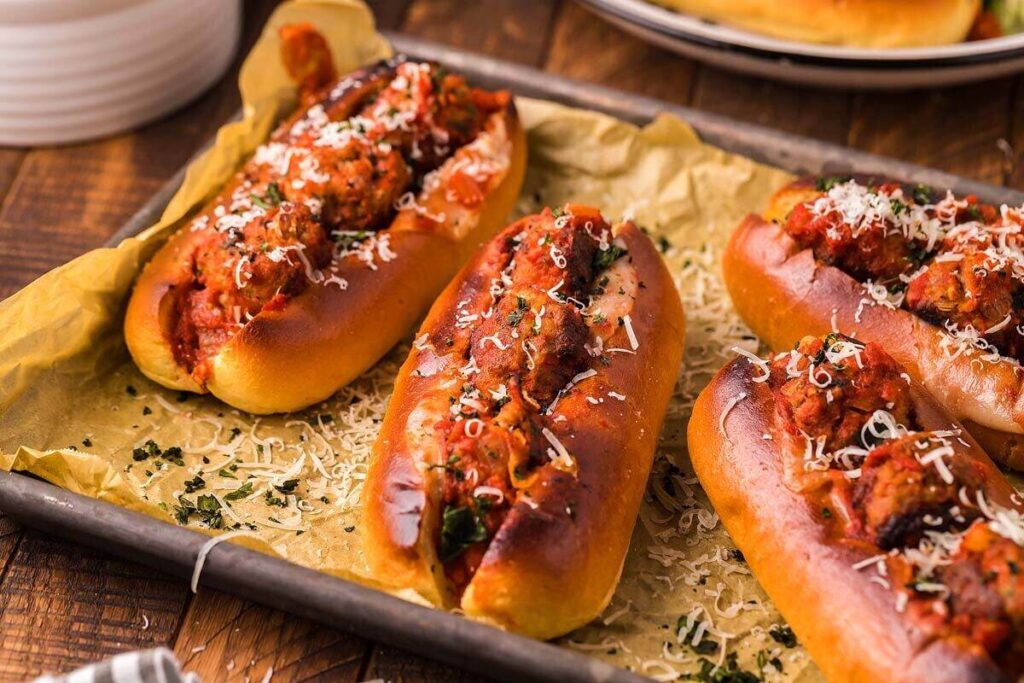 Italian meatball subs with marinara and melted cheese, toasted to perfection on a baking sheet.