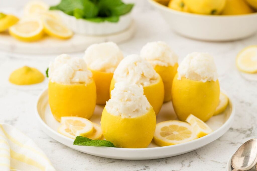 Hollowed lemons filled with lemon sorbet, topped with mint and lemon slices.