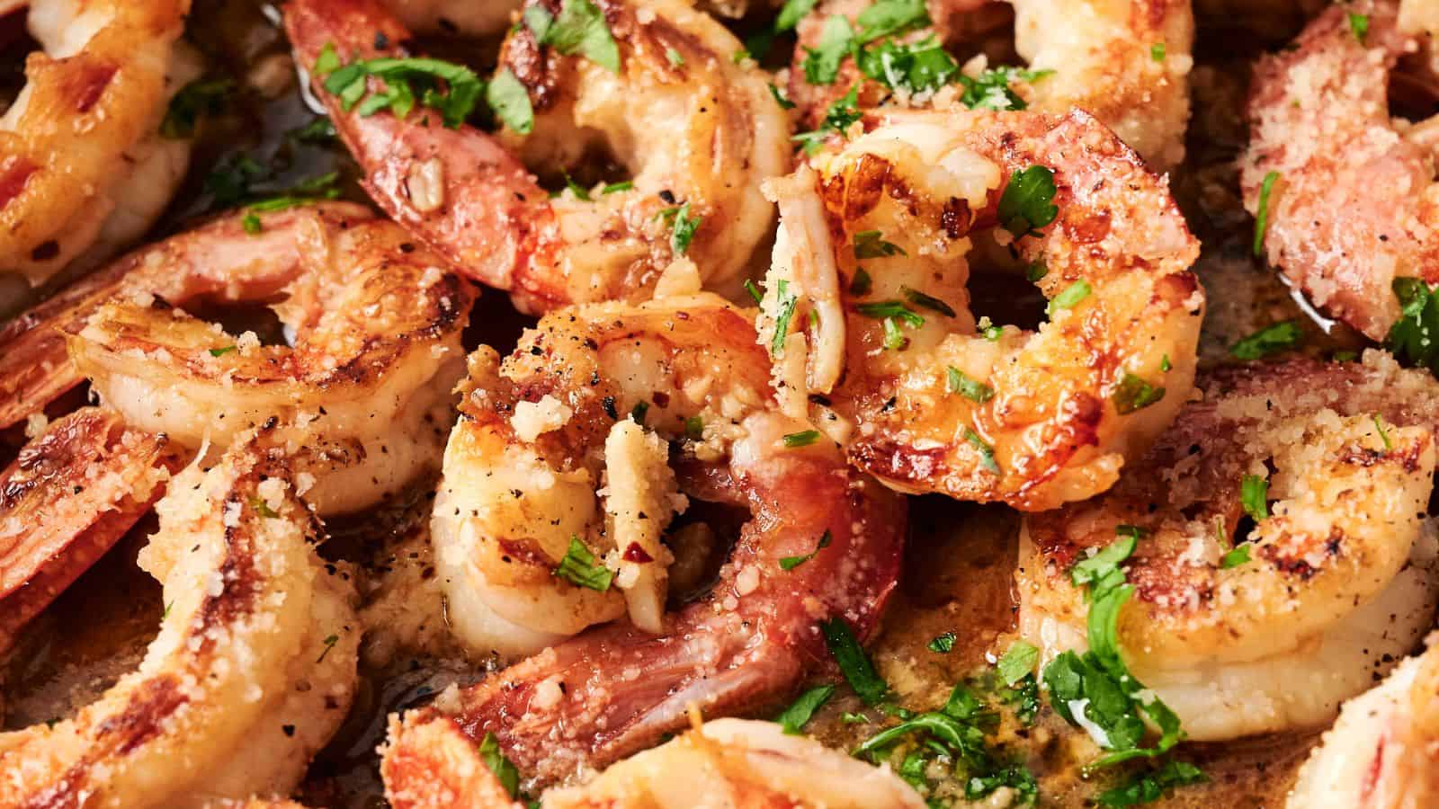 Close-up of cooked shrimp seasoned with herbs and black pepper.