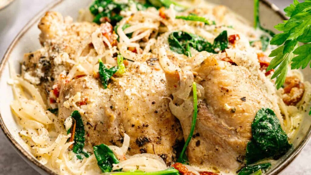 Closeup shot of a bowl of Slow Cooker Chicken Thighs with garnish.