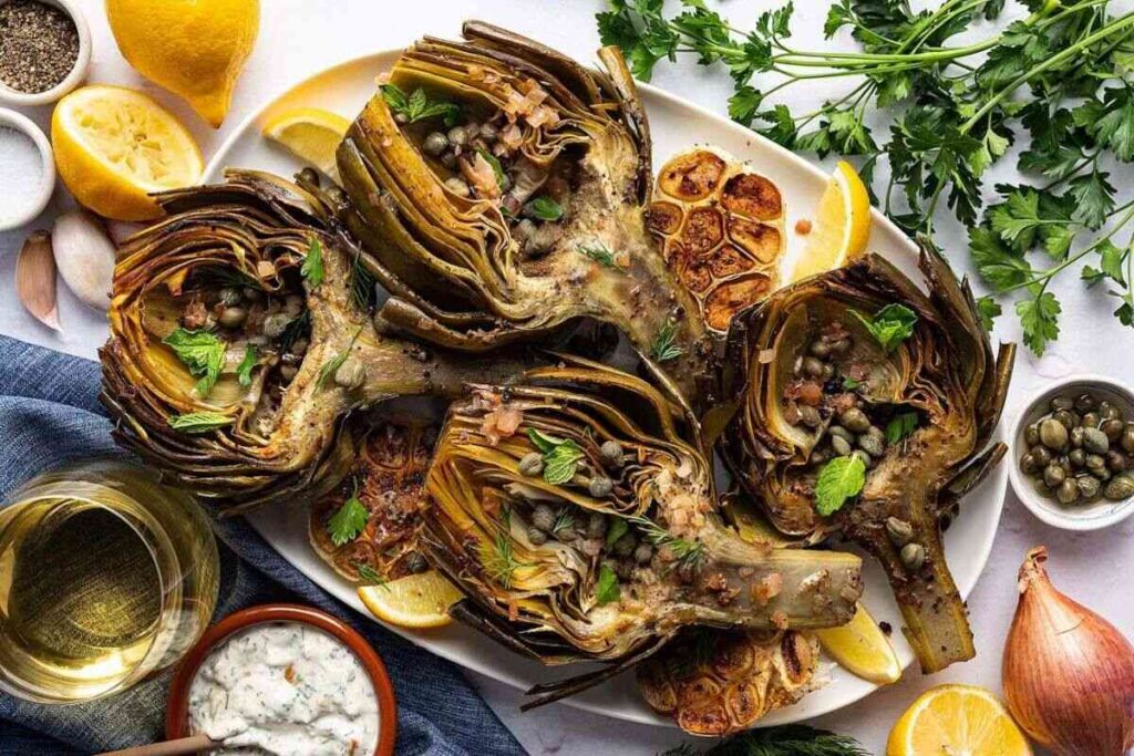 Roasted artichokes with herbs and capers, served with lemon, garlic, and sauce.