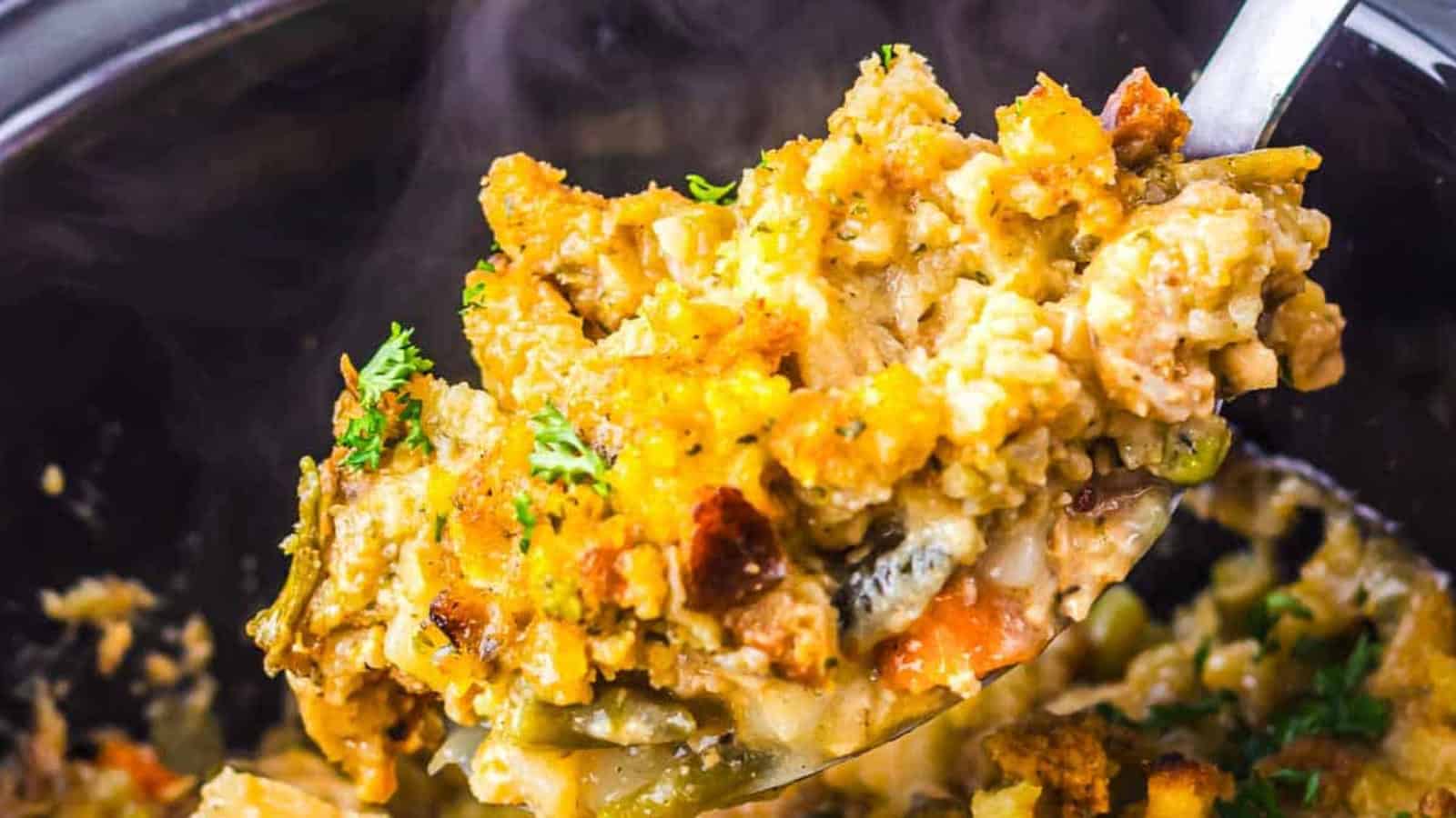Golden-brown stuffing topped with chopped herbs, baked until crispy in a black dish.