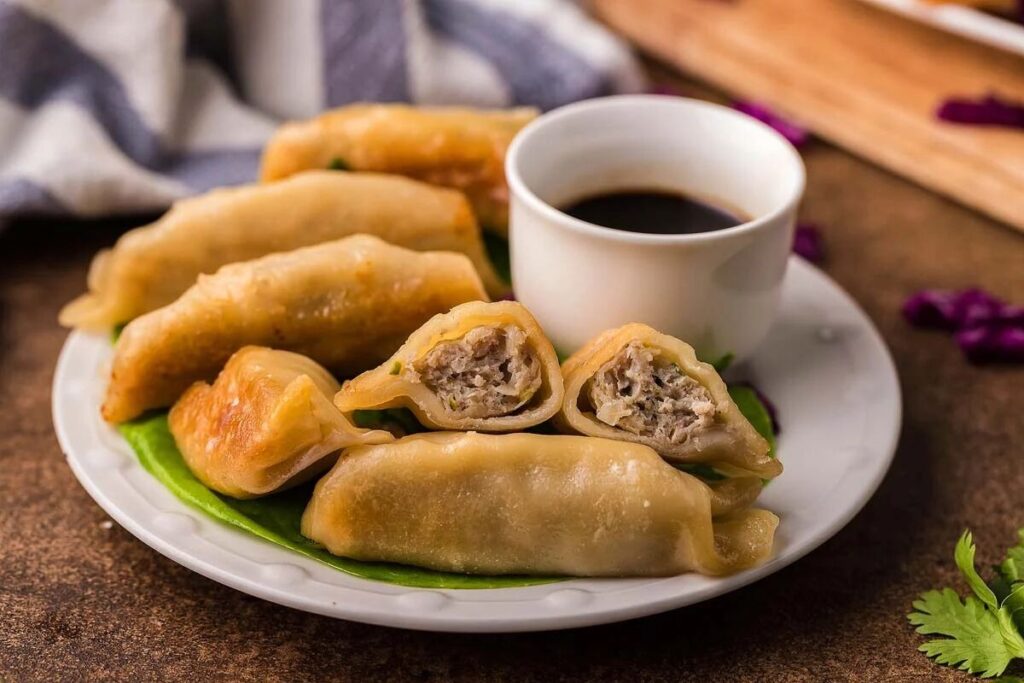 A plate of ground turkey potstickers, with one cut open to reveal the savory filling.