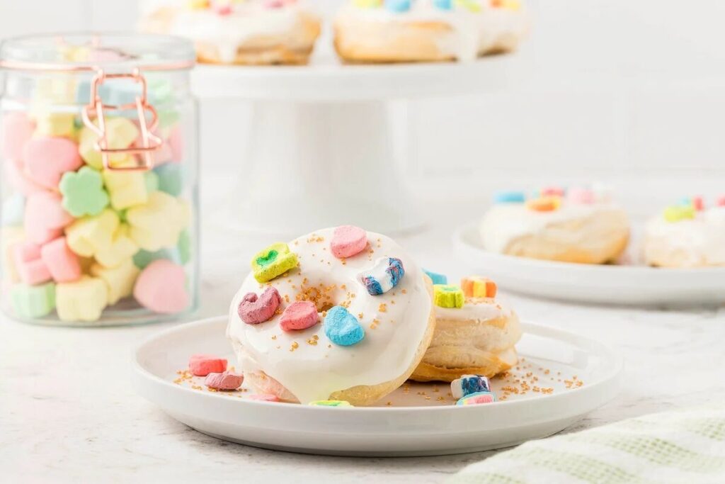  air fryer Lucky Charms marshmallow donuts for St. Patrick's Day or Easter made with canned buttermilk biscuits on a white plate.