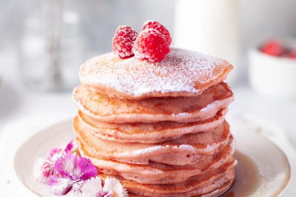 A stack of fluffy beetroot pink pancakes.