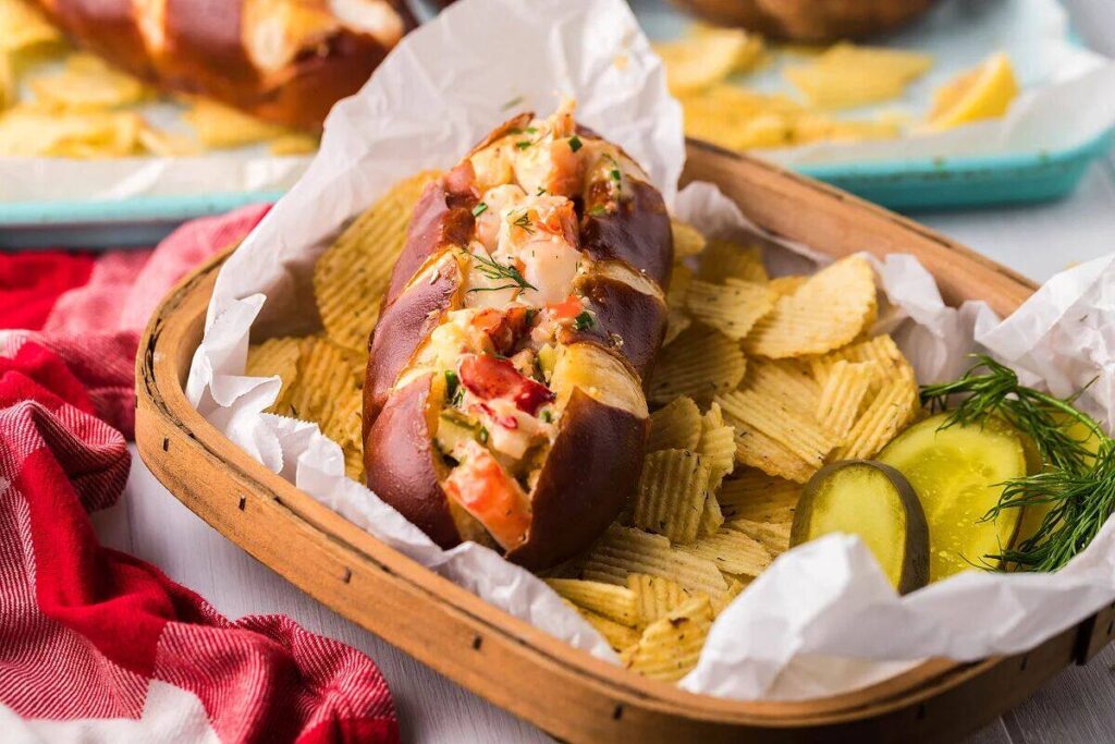 A basket with a lobster roll and some potato chips.