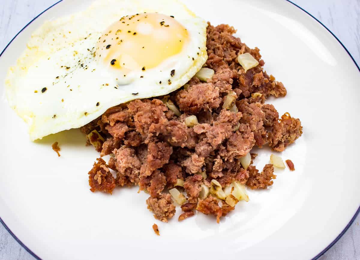 Corned beef hash on a plate with a fried egg.