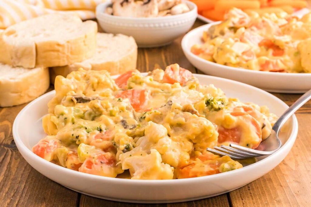 Cheesy Vegetable Casserole on a white plate with a fork.