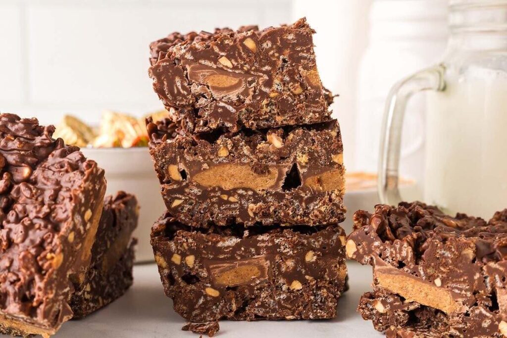 A stack of chocolate peanut butter crunch bars sits on a table.