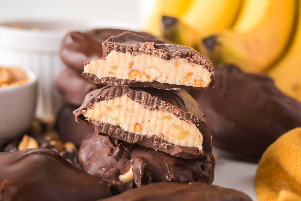Chocolate peanut butter banana bites are stacked, showcasing their enticing layers of creamy filling.