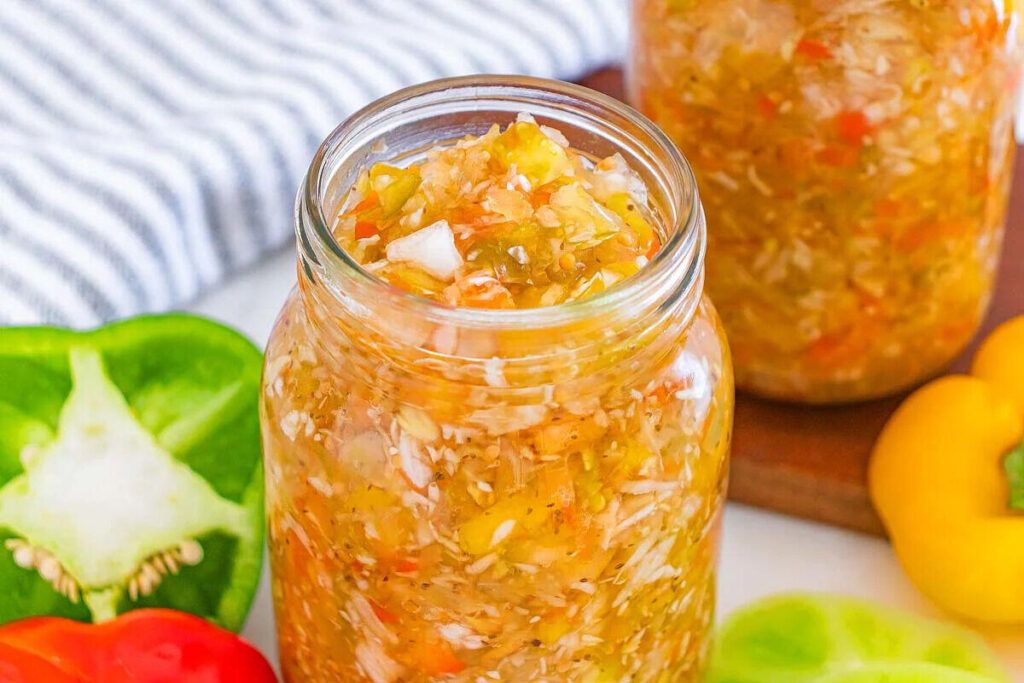 Jar of homemade relish with chopped peppers and onions.