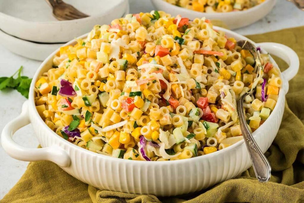 A white ceramic dish filled with coleslaw pasta salad.