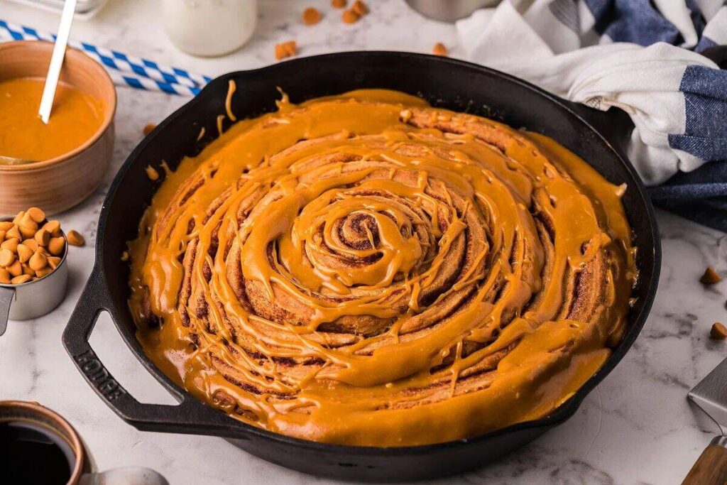 Cinnamon Roll Skillet Cake with butterscotch glaze served in a cast-iron skillet.