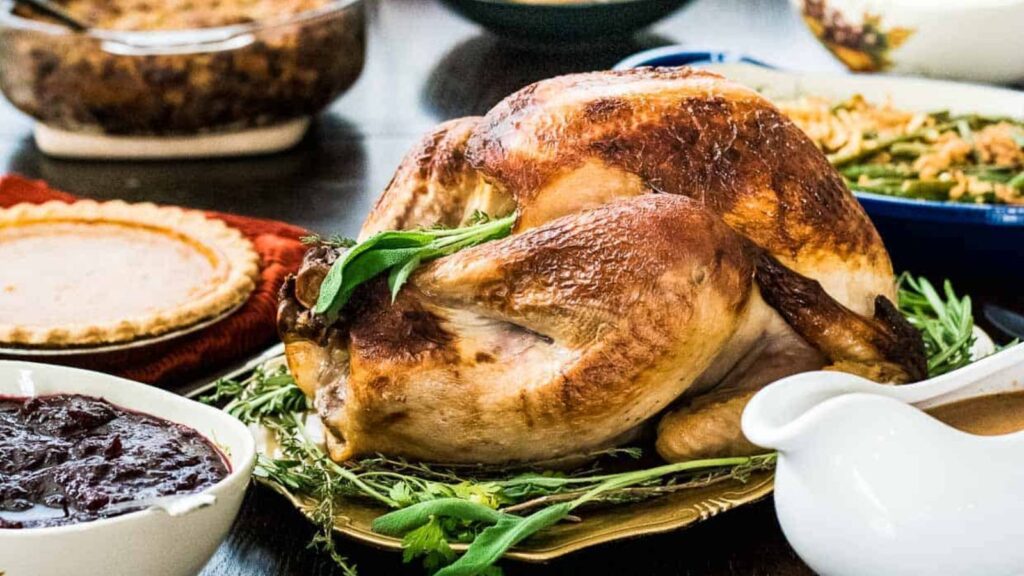 A buttermilk brined roasted surrounded by festive holiday side dishes.