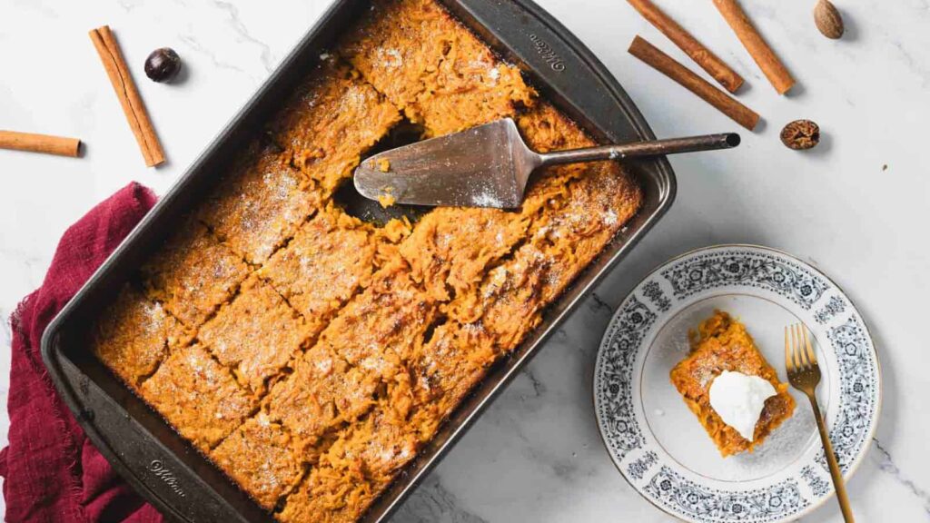 A carrot casserole with a slice taken out.