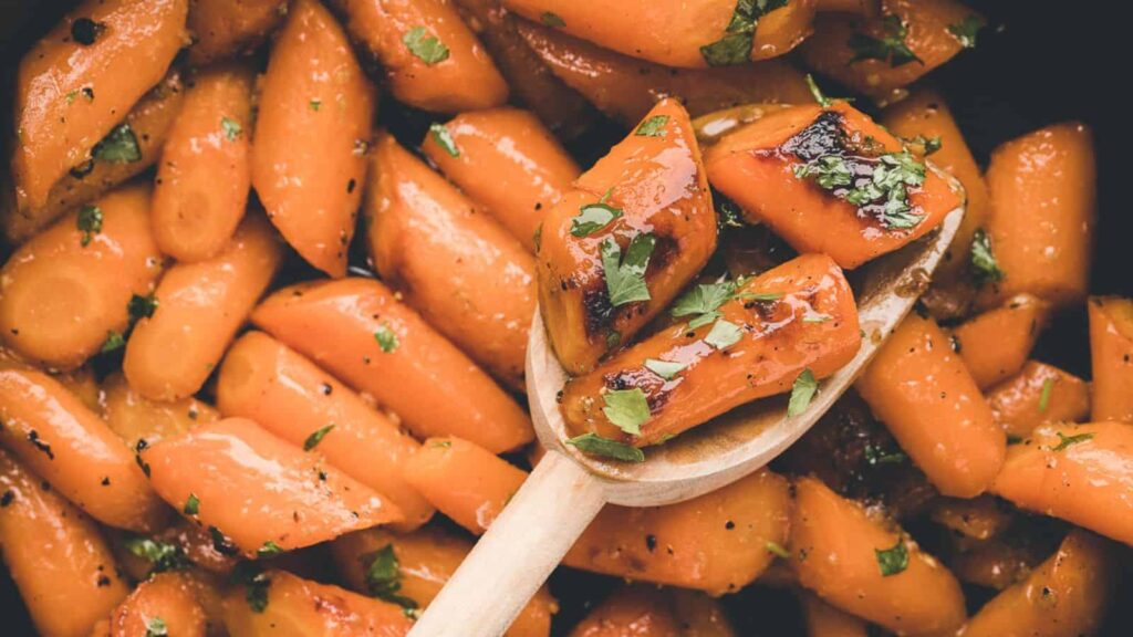 Honey garlic carrots in a black dish.