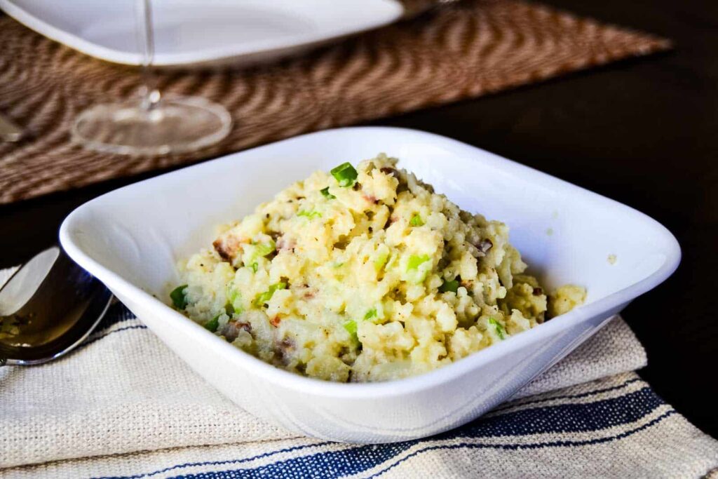 Mashed cauliflower in a white bowl.