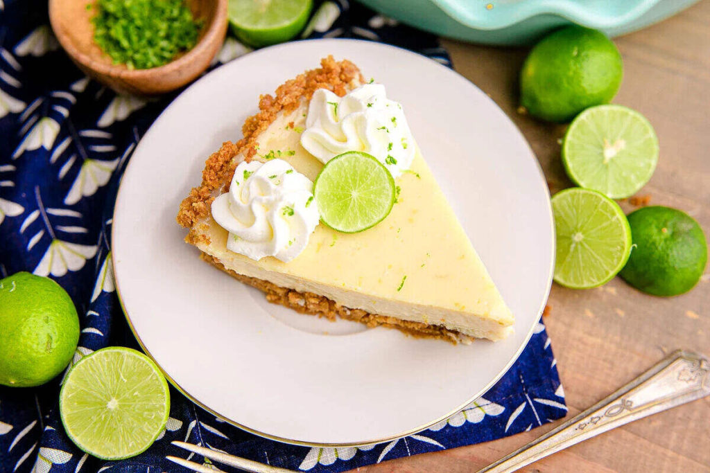 Key lime pie on a plate with whipping cream.