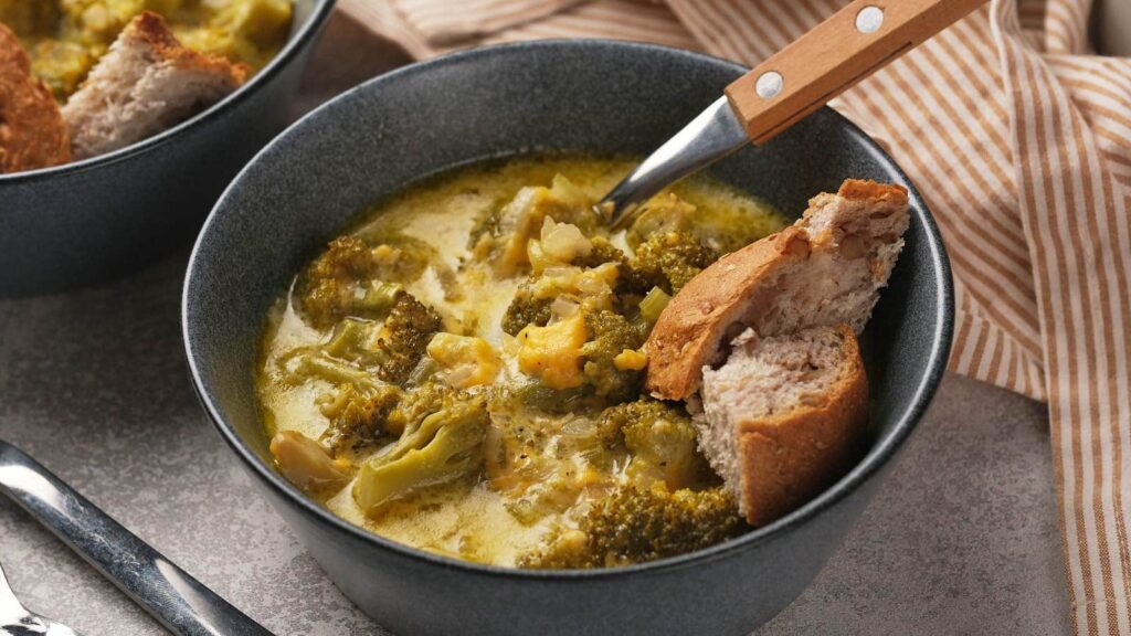 Panera broccoli cheddar soup in a grey bowl.