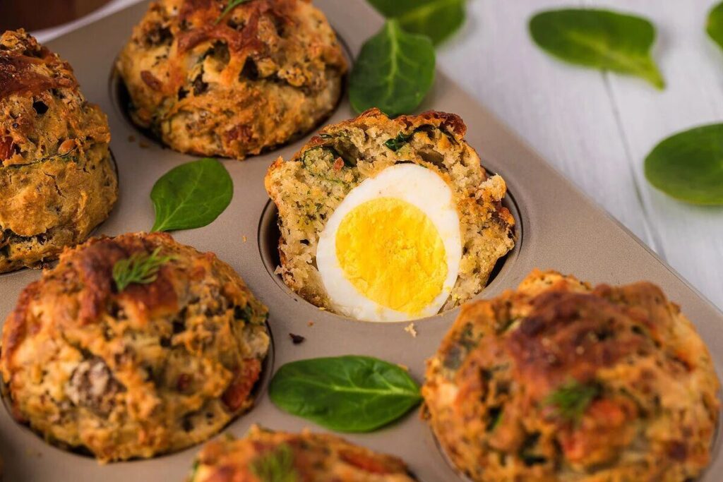 Savoury breakfast muffins with soft boiled egg yolk on a plate.