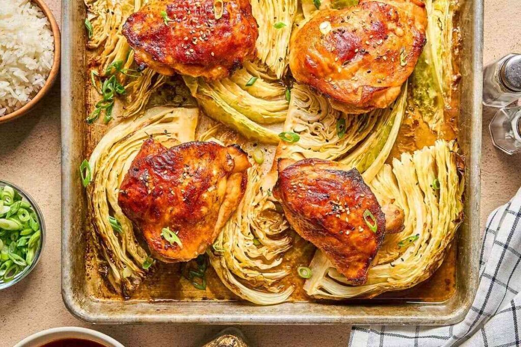 Sheet Pan Gochujang Chicken and Cabbage with roasted chicken thighs, cabbage wedges, and green onions.