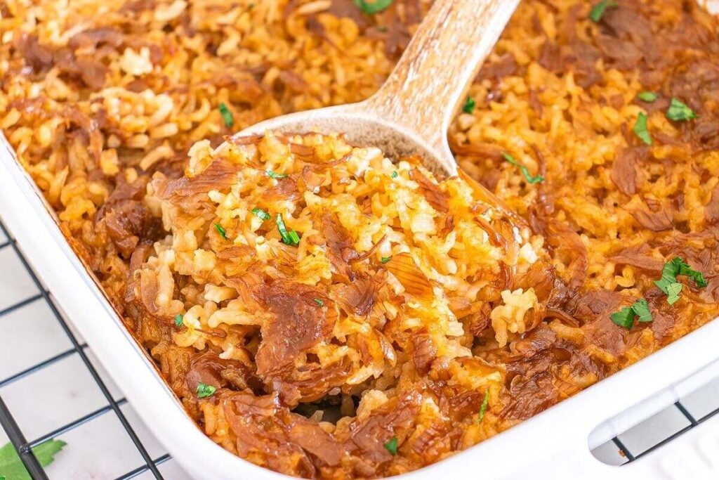 A close-up of a casserole dish filled with baked stick of butter rice.
