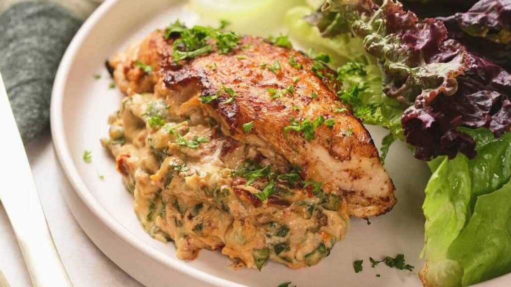 A plate featuring a seasoned piece of grilled chicken breast.