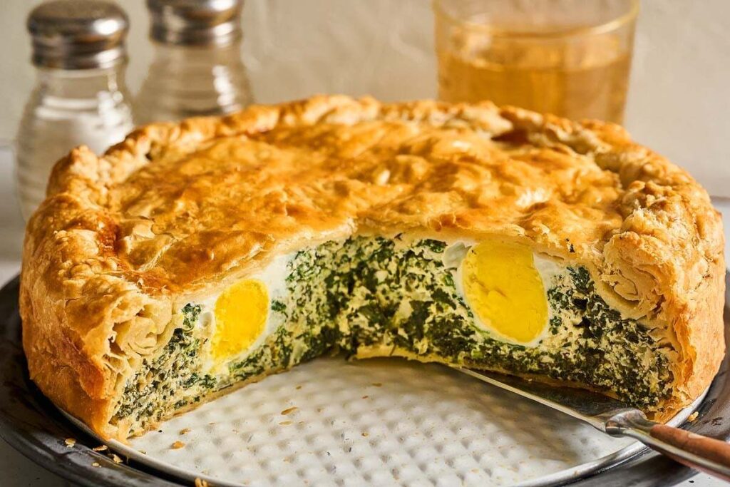Golden Torta Pasqualina filled with spinach and whole eggs.