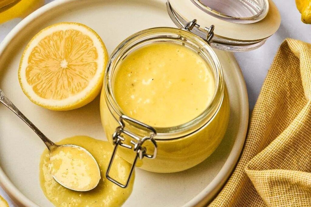 Jar of whole lemon vinaigrette on a plate .