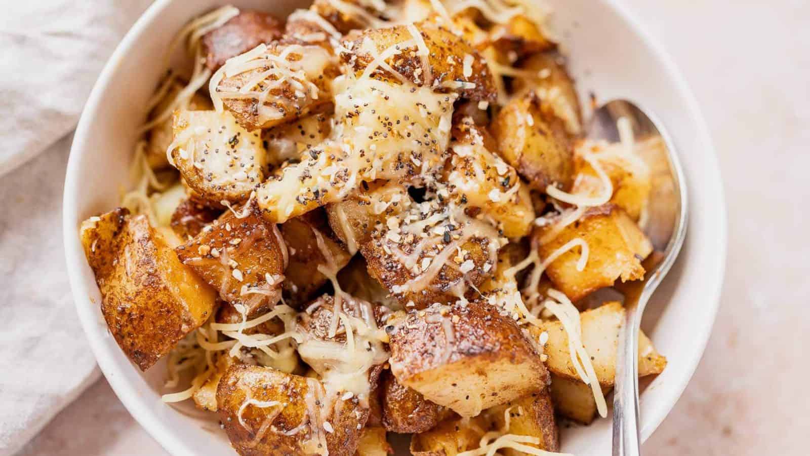 Close up of diced potatoes with melted white cheese on top.
