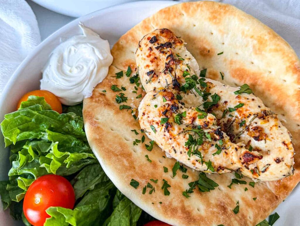 Chicken in a wrap with lettuce and tomatoes.