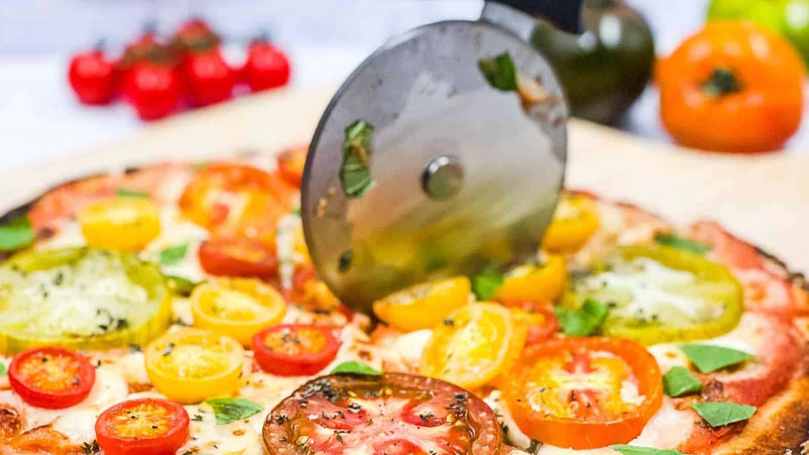Someone slicing a pizza with a pizza cutter.